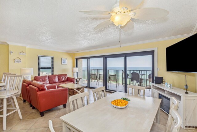 dining area featuring ceiling fan, light tile patterned flooring, a textured ceiling, and ornamental molding