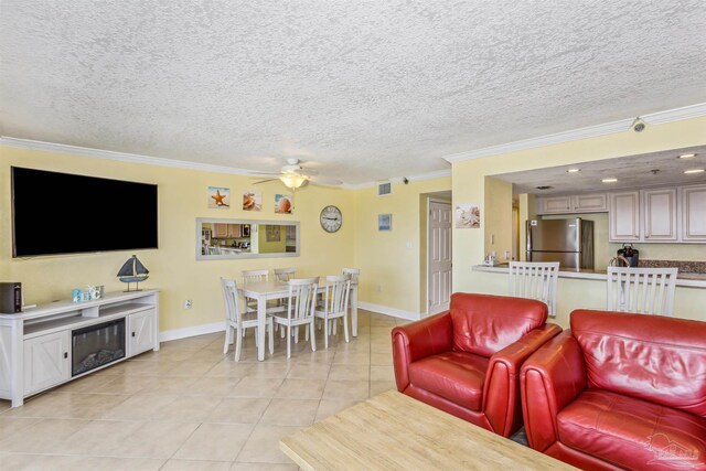 living room featuring light tile patterned flooring, a textured ceiling, crown molding, and ceiling fan