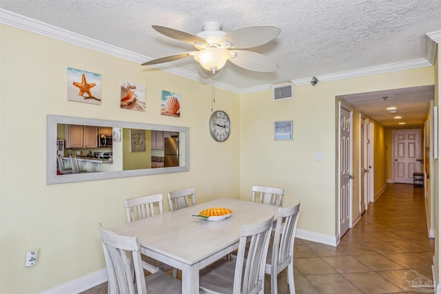 tiled dining space featuring ceiling fan, a textured ceiling, and crown molding