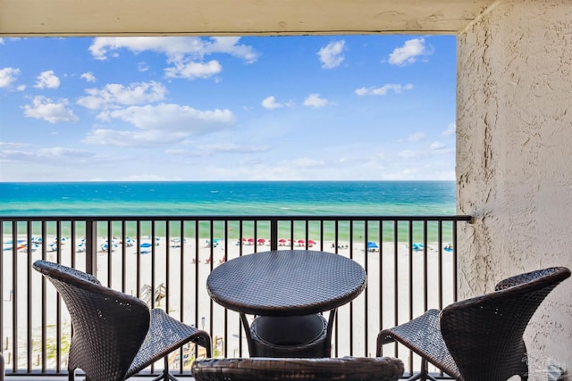 balcony featuring a beach view and a water view