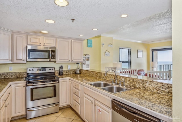 kitchen with stainless steel appliances, a textured ceiling, sink, light tile patterned flooring, and kitchen peninsula