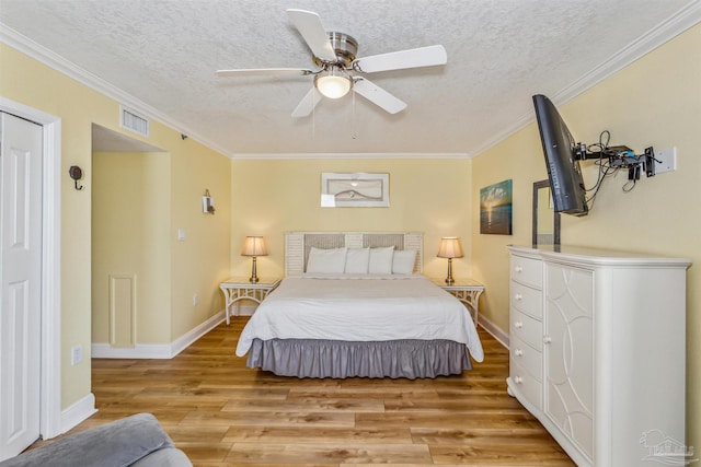 bedroom with light hardwood / wood-style flooring, a textured ceiling, ornamental molding, and ceiling fan