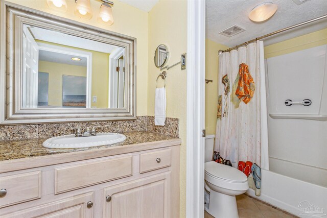 full bathroom with a textured ceiling, shower / bath combo, toilet, tile patterned floors, and vanity