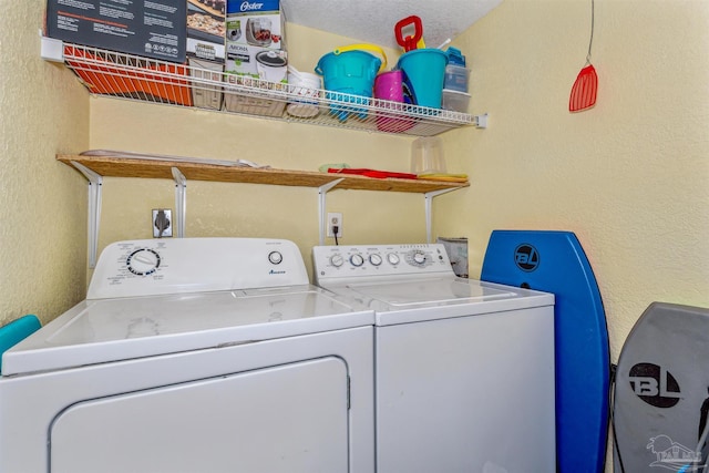 laundry area featuring washer and dryer, a textured ceiling, laundry area, and a textured wall