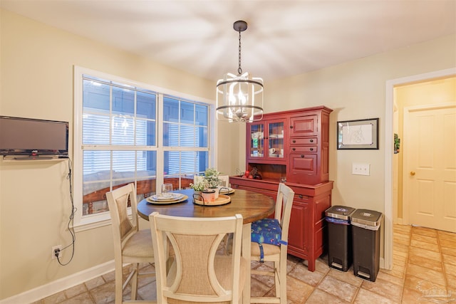 dining space with baseboards and an inviting chandelier