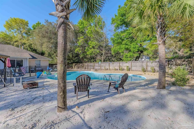 view of swimming pool featuring a fenced in pool, a patio, a fire pit, and fence