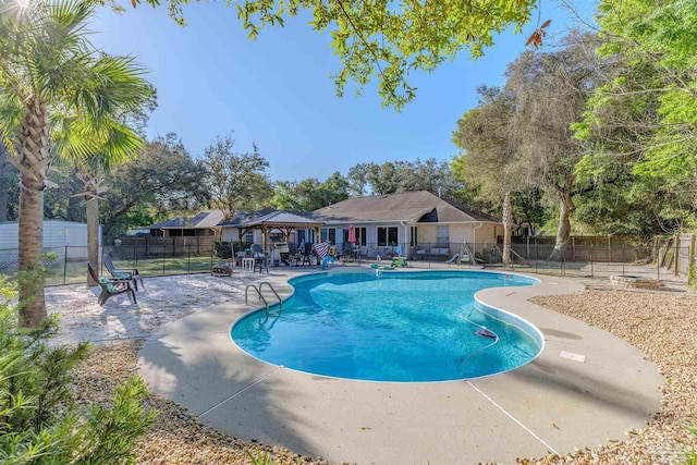 community pool featuring a gazebo, fence, and a patio