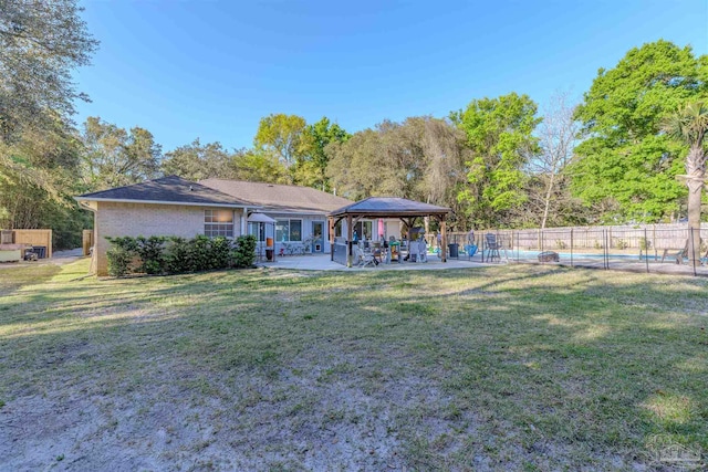 back of house featuring a yard, a patio area, fence, a gazebo, and a fenced in pool