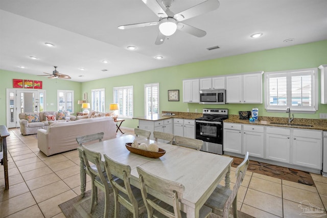 446 Harbor Light Cir, Gulf Shores, AL 36542 - kitchen featuring appliances with stainless steel finishes, a sink, a ceiling fan, white cabinets, and light tile patterned flooring