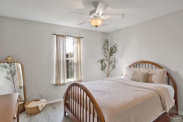 bedroom featuring hardwood / wood-style flooring, ceiling fan, and a textured ceiling