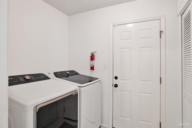 laundry room featuring washer and clothes dryer and a textured ceiling