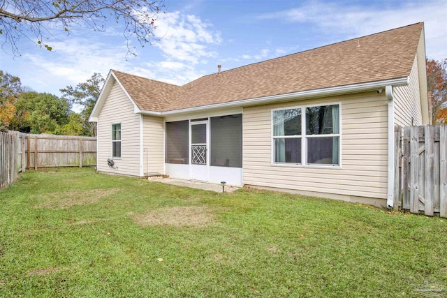 back of property featuring a sunroom and a lawn