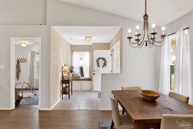 dining space with lofted ceiling, light wood-type flooring, and ceiling fan with notable chandelier