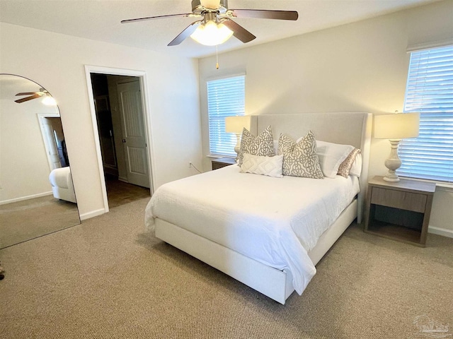 carpeted bedroom with multiple windows and ceiling fan