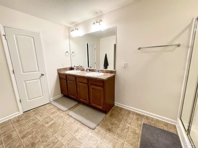 bathroom with vanity, a textured ceiling, and an enclosed shower