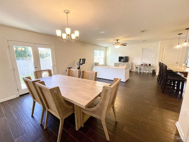 dining room featuring ceiling fan with notable chandelier, a textured ceiling, and french doors