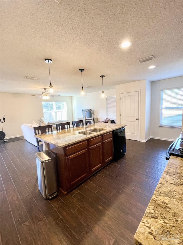 kitchen with dishwasher, sink, a healthy amount of sunlight, hanging light fixtures, and a center island with sink