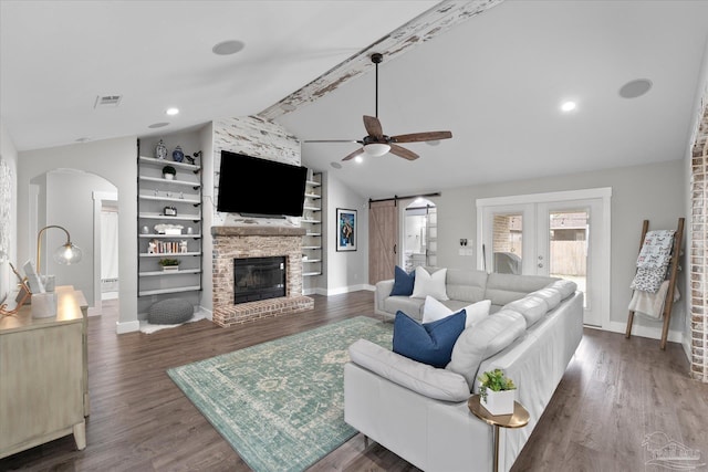 living room with dark hardwood / wood-style floors, ceiling fan, a barn door, and vaulted ceiling with beams