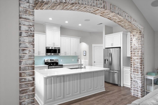 kitchen featuring white cabinetry, appliances with stainless steel finishes, sink, and an island with sink