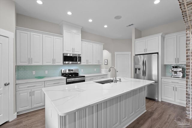 kitchen with sink, a center island with sink, white cabinets, and appliances with stainless steel finishes