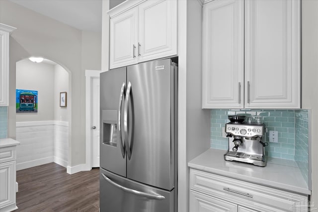 kitchen with dark hardwood / wood-style flooring, decorative backsplash, stainless steel fridge, and white cabinets