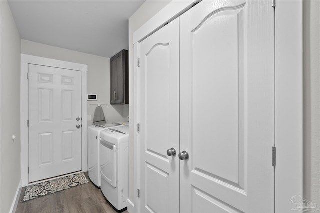 washroom with cabinets, dark hardwood / wood-style floors, and washer and dryer