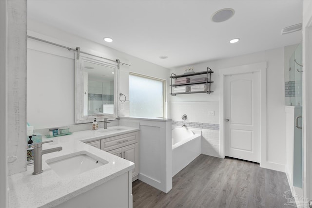 bathroom with independent shower and bath, vanity, and wood-type flooring