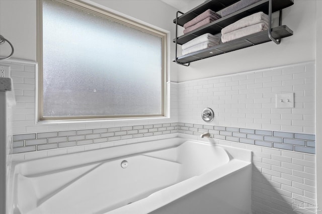 bathroom with a tub and tile walls