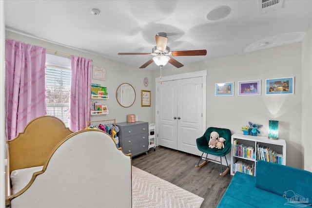 bedroom featuring dark hardwood / wood-style floors, ceiling fan, and a closet