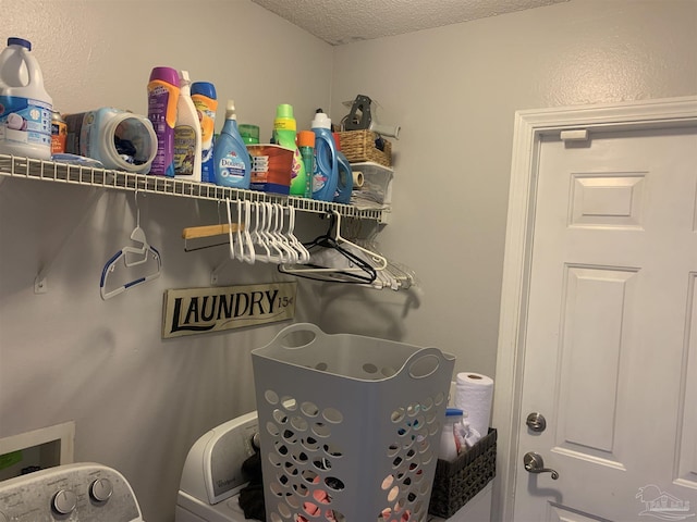 interior space featuring laundry area, washing machine and clothes dryer, and a textured ceiling