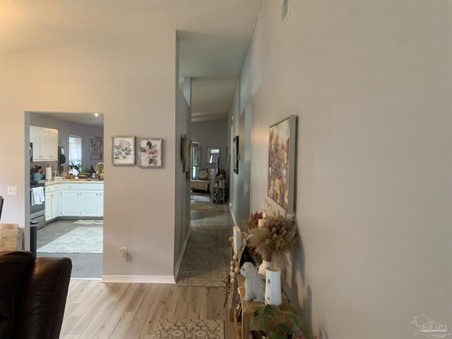 corridor featuring baseboards and wood finished floors