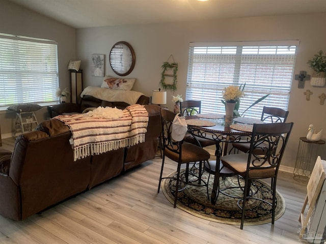 bedroom with baseboards, lofted ceiling, and light wood finished floors