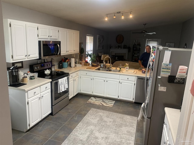 kitchen featuring a sink, white cabinetry, appliances with stainless steel finishes, light countertops, and ceiling fan