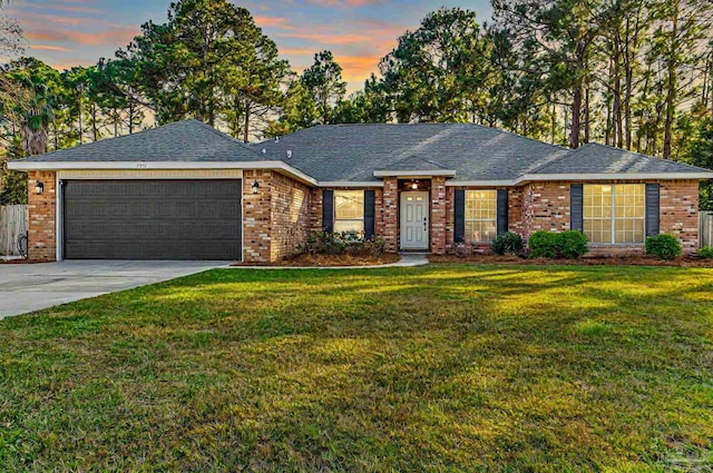 ranch-style home with a yard and a garage