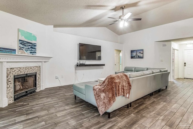 living room with hardwood / wood-style floors, a textured ceiling, ceiling fan, and lofted ceiling