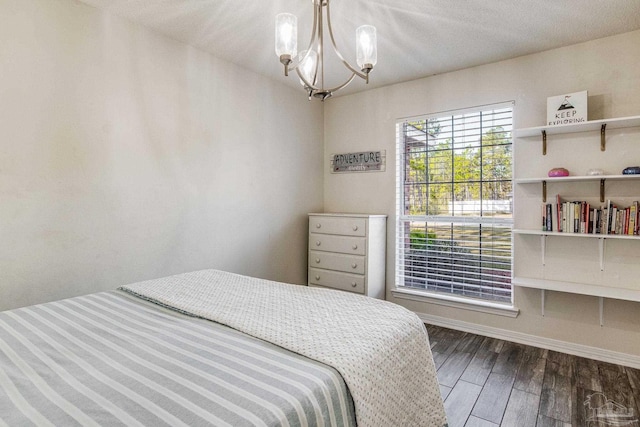 bedroom with dark hardwood / wood-style flooring, a chandelier, and a textured ceiling