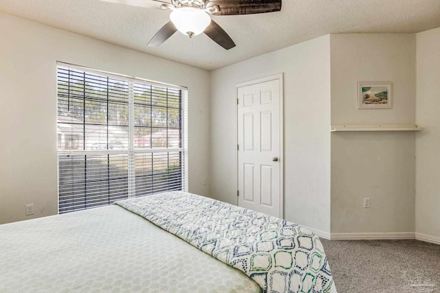 bedroom featuring ceiling fan, carpet floors, and a textured ceiling