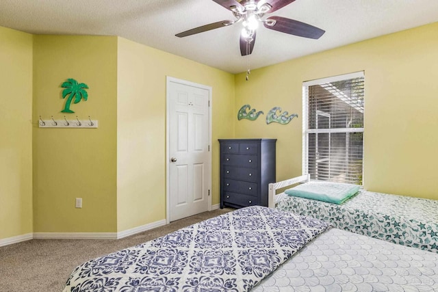 bedroom with ceiling fan, carpet floors, and a textured ceiling