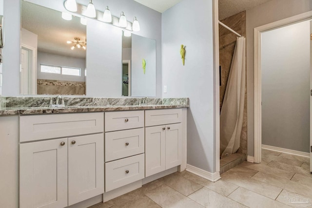 bathroom featuring a shower with shower curtain, vanity, and a textured ceiling