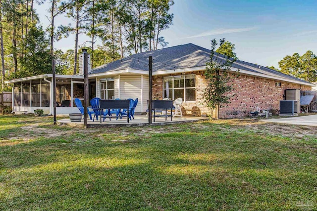 rear view of property featuring a patio area, a sunroom, and a yard