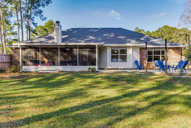 back of house featuring a sunroom, a patio area, and a yard