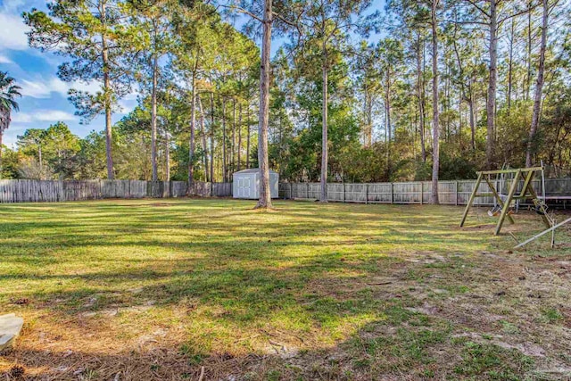 view of yard with a storage shed and a playground