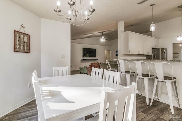 dining space featuring a textured ceiling, lofted ceiling, ceiling fan with notable chandelier, and dark hardwood / wood-style floors