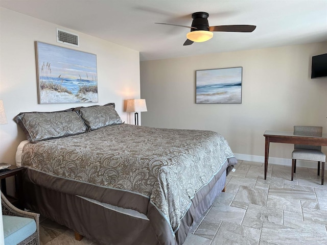 bedroom with stone finish floor, baseboards, visible vents, and ceiling fan