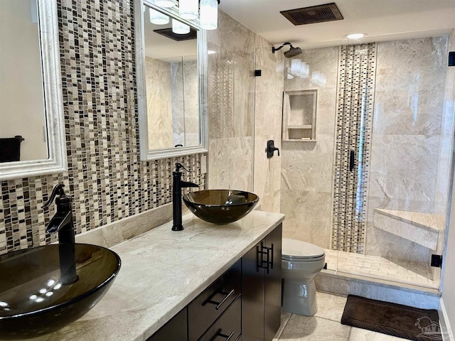 bathroom with a stall shower, visible vents, backsplash, and a sink