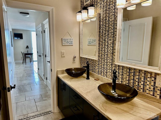 bathroom with decorative backsplash, a sink, and stone tile floors