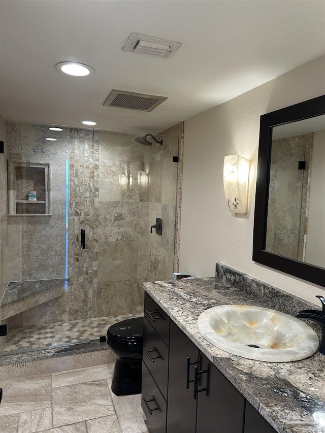 bathroom with a stall shower, visible vents, vanity, and toilet