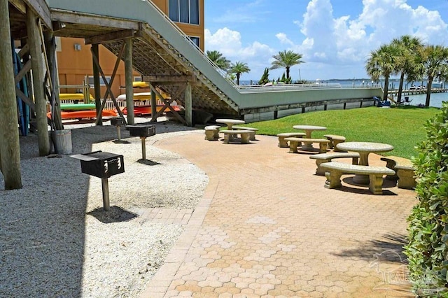 view of home's community with stairs, a patio, and a lawn