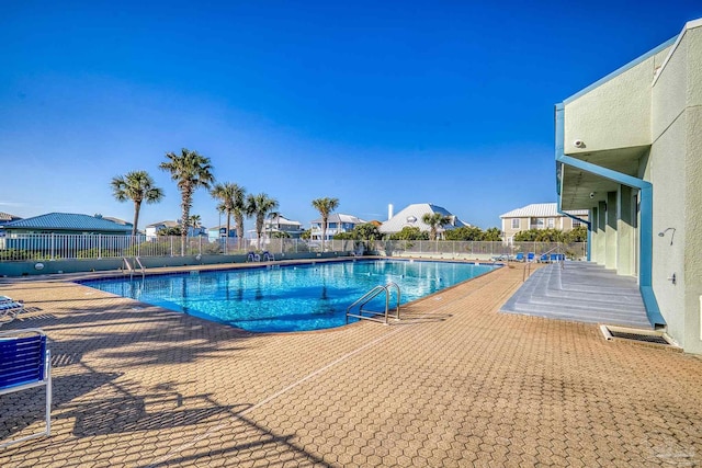 community pool with fence and a patio