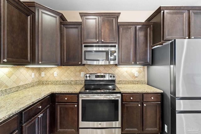 1824 Lindsey Magnolia Ct, Navarre, FL 32566 - kitchen featuring appliances with stainless steel finishes, dark brown cabinetry, and tasteful backsplash